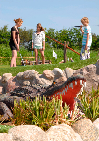 Crocodile in front of kids playing adventure golf