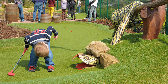 Young boy looking for his ball in the adventure golf snake
